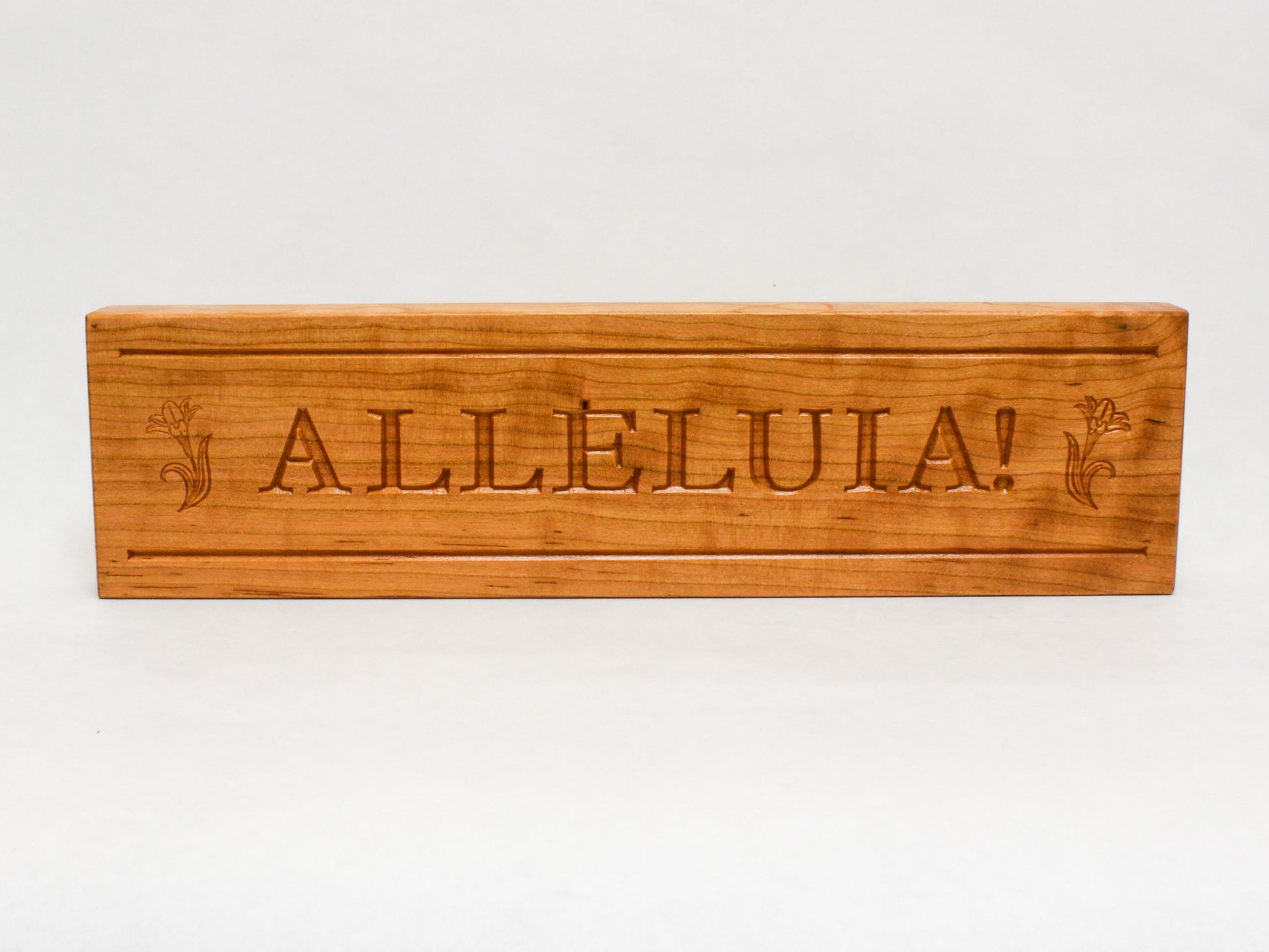 Wooden Alleluia mantle sign for Easter decoration. Freestanding wooden block engraved with Alleluia in classic text with simple Easter lily on either side.
